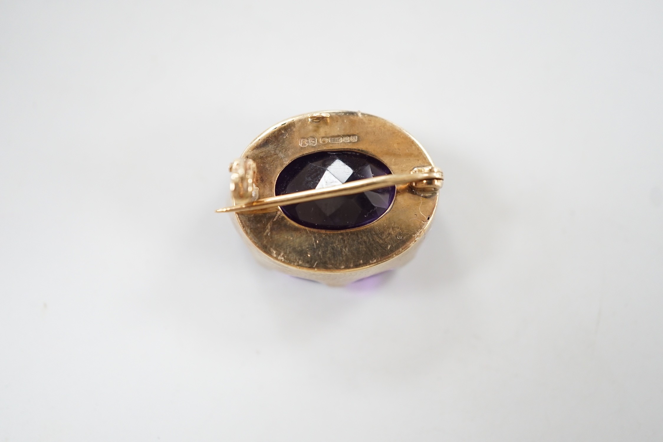 A modern 9ct gold mounted oval facet cut amethyst brooch, 22mm, gross weight 8.5 grams.